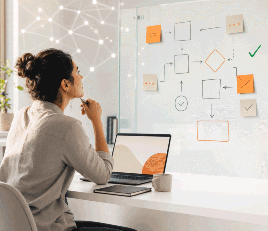 AI and Software Development Jobs in 2026: 5 Roles That Are Growing and How to Stay Hireable Software developer turning from a laptop keyboard toward a planning board, representing the shift in software jobs as AI changes the work in 2026.